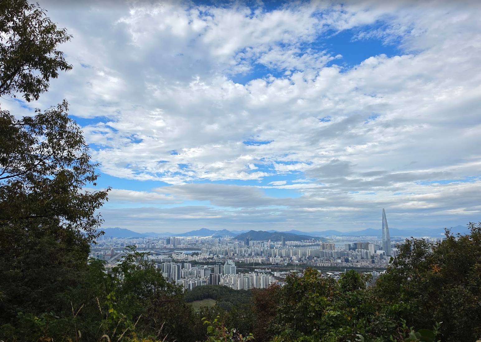 Seoul seen from Guryongsan toward distant mountains, Lotte World Tower visible