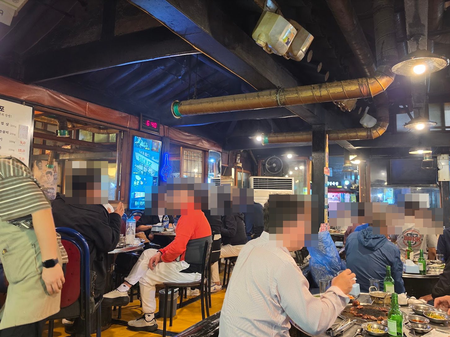 A busy neighborhood samgyeopsal restaurant; diners pixelated for privacy