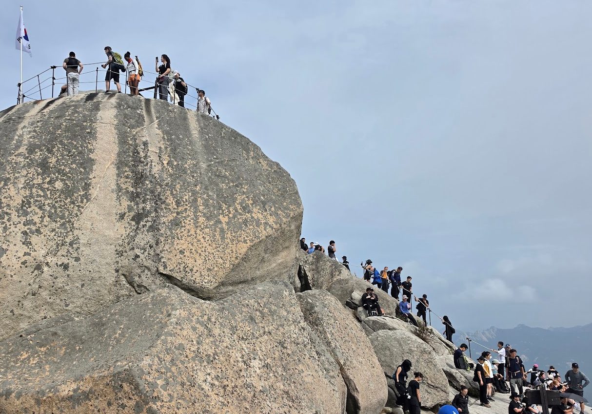 Hikers on the rocky Baegundae summit of Bukhansan
