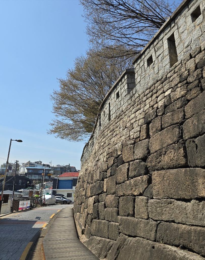 The stone Seoul City Wall beside quiet Jangchung-dong alleys